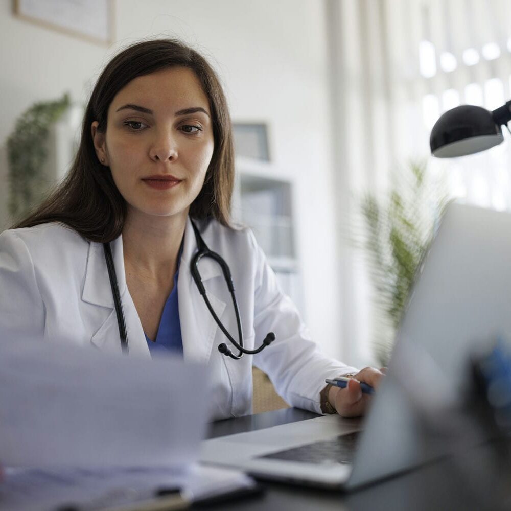 Clinician reviewing documents during an independent medical evaluation