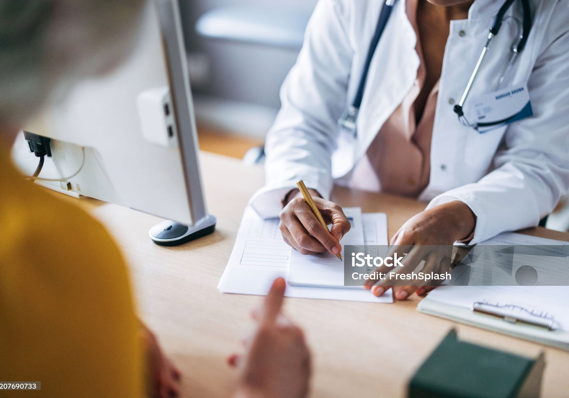A doctor listens attentively to a patient during a consultation, fostering trust and professionalism.