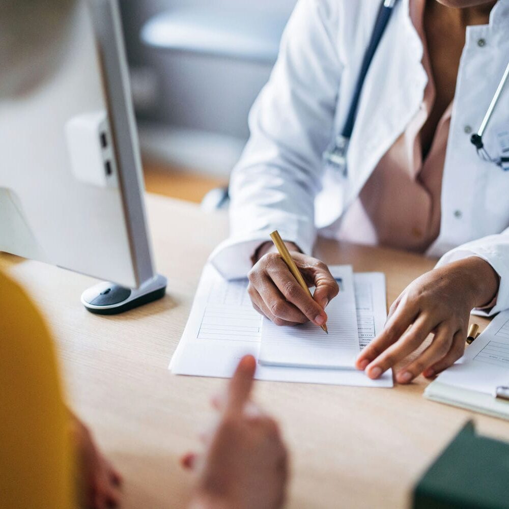 Clinician completing medical assessment documentation during a professional consultation