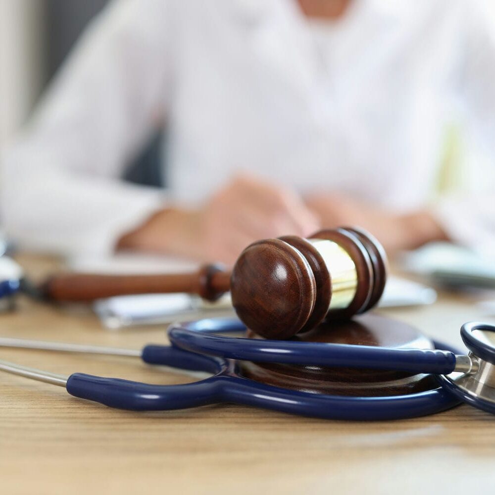 Medical and legal tools on a desk representing the evaluation and reporting process